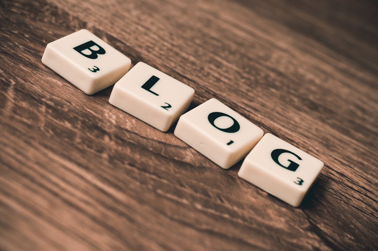 Scrabble tiles spelling BLOG on a wooden background, symbolizing creativity and writing.